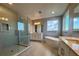 Bathroom boasts dual vanities, a soaking tub under a large window, and glass shower at 3295 Roseville Dr, Apopka, FL 32712