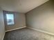 Cozy bedroom featuring neutral walls, gray carpet, and a bright window offering natural light at 3295 Roseville Dr, Apopka, FL 32712