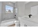 Bathroom boasts modern fixtures including a tub and white vanity with stylish, dark accents at 4683 Sw 136Th St, Ocala, FL 34473