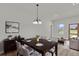 Dining room featuring modern light fixture, dark wood table set and neutral walls at 4683 Sw 136Th St, Ocala, FL 34473