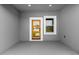 Modern home entry features a wood-framed glass door, white trim window, and gray walls at 4683 Sw 136Th St, Ocala, FL 34473
