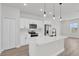 Modern white kitchen with stainless steel appliances, quartz countertops, and pendant lighting at 4683 Sw 136Th St, Ocala, FL 34473