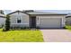 One story home with gray exterior, two car garage, and landscaped lawn at 5174 Minneola Ln, Saint Cloud, FL 34772