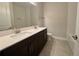 A modern bathroom is complete with double sinks, dark cabinets, and a bathtub with tile surround at 3263 Roseville Dr, Apopka, FL 32712