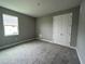 Cozy bedroom featuring neutral-colored walls, carpet flooring, window and a closet with double doors at 3271 Roseville Dr, Apopka, FL 32712