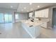 Bright, modern kitchen with large island, stainless steel appliances and sliding glass doors leading to the backyard at 3271 Roseville Dr, Apopka, FL 32712