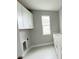 Bright laundry room featuring white cabinets, countertops, and tile flooring, including a utility sink at 3271 Roseville Dr, Apopka, FL 32712