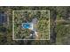 An aerial view displays a lovely property with a pool and surrounding trees offering privacy at 1822 Se 8Th St, Ocala, FL 34471