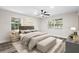 Stylishly staged bedroom featuring neutral tones, a ceiling fan, and natural light from large windows at 1822 Se 8Th St, Ocala, FL 34471