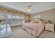 Cozy bedroom with plush carpeting, window with floral valance, ceiling fan and white furniture at 4831 Saxon Dr # 2270, New Smyrna Beach, FL 32169