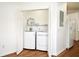 Convenient in-unit laundry closet featuring a washer, dryer, shelving, and wood flooring at 570 Cranes Way # 248, Altamonte Springs, FL 32701