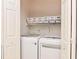 Convenient laundry room with washer, dryer, and shelving, optimizing space for laundry tasks at 570 Cranes Way # 248, Altamonte Springs, FL 32701