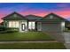 Charming single-story home featuring a manicured lawn and inviting curb appeal at dusk at 8038 Glitter Ct, Orlando, FL 32836