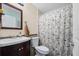 Clean bathroom with a floral shower curtain and dark wood vanity at 12013 Woodglen Cir, Clermont, FL 34711