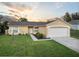 Cute one-story house with a well-manicured lawn and a two-car garage at 12013 Woodglen Cir, Clermont, FL 34711