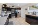 Modern kitchen with dark wood cabinets, stainless steel appliances, and a tile floor at 12013 Woodglen Cir, Clermont, FL 34711