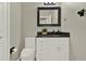 Neutral powder room featuring a sleek vanity with a black countertop and modern fixtures at 2685 Star Grass Cir, Kissimmee, FL 34746