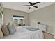 Bright bedroom featuring a ceiling fan, window bench, and sleek white dresser at 2685 Star Grass Cir, Kissimmee, FL 34746