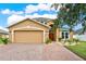 Lovely exterior elevation view showcasing the home with paver driveway and well-maintained landscaping at 2685 Star Grass Cir, Kissimmee, FL 34746