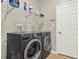 Laundry room with modern washer and dryer units and shelving at 2685 Star Grass Cir, Kissimmee, FL 34746