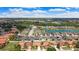 This aerial view shows a residential neighborhood with grey and red roofs and a pond at 3047 Sangria St, Kissimmee, FL 34744