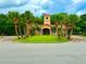 Community clubhouse featuring a well-maintained lawn and picturesque landscaping with palm trees at 3047 Sangria St, Kissimmee, FL 34744