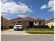 Exterior view of a well-maintained home with a two-car garage, lovely landscaping, and a beautifully tiled roof at 3047 Sangria St, Kissimmee, FL 34744