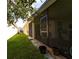 View of the screened-in patio from the backyard, with brick pavers and mature landscaping at 3047 Sangria St, Kissimmee, FL 34744