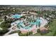 An aerial view of the community pool and water park, surrounded by community houses at 8938 Cabot Cliffs Dr, Davenport, FL 33896
