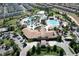 Aerial view of community clubhouse and multiple swimming pools lined with mature palm trees at 8938 Cabot Cliffs Dr, Davenport, FL 33896