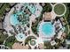 Aerial view of a resort style pool with lounge chairs, palm trees, umbrellas, splash pad, and circular pool at 8938 Cabot Cliffs Dr, Davenport, FL 33896