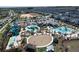 Aerial view showcasing the community's pools, water slides, splashpad, and surrounding neighborhood at 8938 Cabot Cliffs Dr, Davenport, FL 33896
