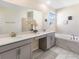 Bright bathroom featuring double vanity, large mirror, soaking tub with tile surround and decor at 8938 Cabot Cliffs Dr, Davenport, FL 33896