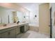 Well-lit bathroom featuring double sinks, a soaking tub, and elegant marble accents at 8938 Cabot Cliffs Dr, Davenport, FL 33896