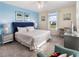 Stylish bedroom with a blue accent wall, large windows, and neutral carpeting, creating a relaxing retreat at 8938 Cabot Cliffs Dr, Davenport, FL 33896