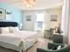 Inviting bedroom featuring blue accent wall, comfortable chair, and ample natural light from the window at 8938 Cabot Cliffs Dr, Davenport, FL 33896