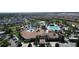 Aerial view of a beautiful community clubhouse with a resort style pool, palm trees, and ample parking at 8938 Cabot Cliffs Dr, Davenport, FL 33896