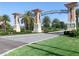 Grand ChampionsGate entrance featuring decorative pillars, tropical landscaping, and clear signage for residents and guests at 8938 Cabot Cliffs Dr, Davenport, FL 33896