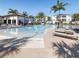 Large community pool with plenty of lounge chairs, tables and shady umbrellas at 8938 Cabot Cliffs Dr, Davenport, FL 33896