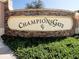 Elegant ChampionsGate community sign with stone backdrop surrounded by lush greenery, creating an inviting atmosphere at 8938 Cabot Cliffs Dr, Davenport, FL 33896