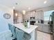 Bright kitchen with stainless appliances, a large island, pendant lighting and modern gray cabinetry at 8938 Cabot Cliffs Dr, Davenport, FL 33896