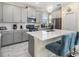 Open kitchen boasts stainless steel appliances, quartz countertops, and island with bar seating at 8938 Cabot Cliffs Dr, Davenport, FL 33896