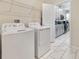 Bright laundry room featuring a side-by-side washer and dryer and a wire shelf, conveniently located near the kitchen at 8938 Cabot Cliffs Dr, Davenport, FL 33896