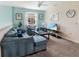 Comfortable living room area with soft blue walls, neutral carpeting, ceiling fan, and natural light at 8938 Cabot Cliffs Dr, Davenport, FL 33896
