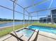 Screened-in pool with a spa offers relaxing views of a beautiful pond and backyard at 8938 Cabot Cliffs Dr, Davenport, FL 33896