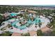 Aerial view of a resort-style pool with palm trees, lounge chairs, and a clubhouse, providing a luxurious outdoor experience at 8938 Cabot Cliffs Dr, Davenport, FL 33896