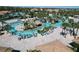 A large resort-style pool surrounded by palm trees, lounge chairs, and a tropical-themed bar area for relaxation and enjoyment at 8938 Cabot Cliffs Dr, Davenport, FL 33896