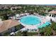 Aerial view of a large, circular pool with plenty of lounge chairs and umbrellas for residents to enjoy swimming and relaxing at 8938 Cabot Cliffs Dr, Davenport, FL 33896