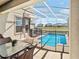 Inviting outdoor patio with a screened-in pool area, complete with dining space and views of the serene pond at 8938 Cabot Cliffs Dr, Davenport, FL 33896