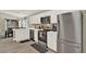 Modern kitchen featuring stainless steel appliances, white cabinetry, and wood flooring at 188 Ridgemont Ct, Davenport, FL 33896